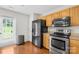 Modern kitchen featuring stainless steel appliances, wooden cabinets, and a convenient side door access at 1023 Valley Ridge Rd, Charlotte, NC 28214