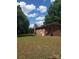 Exterior view of a brick home featuring a screened-in porch and a spacious backyard at 10500 Bethel Church Rd, Midland, NC 28107