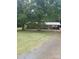 Charming single-story brick home with a metal roof and a covered carport surrounded by mature trees at 10500 Bethel Church Rd, Midland, NC 28107