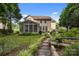Landscaped backyard with a stone walkway leading to a screened-in porch at 10703 Back Ridge Rd, Charlotte, NC 28277