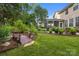 Landscaped backyard featuring a charming wooden bridge leading to the screened-in back porch at 10703 Back Ridge Rd, Charlotte, NC 28277