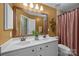 Well-lit bathroom featuring a double vanity with modern fixtures and tiled shower with tub at 10703 Back Ridge Rd, Charlotte, NC 28277