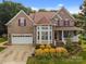 Charming brick home with well-manicured landscaping and inviting front porch, plus a two-car garage at 10703 Back Ridge Rd, Charlotte, NC 28277