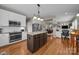 Open-concept kitchen with island, white cabinets and adjacent living area at 10703 Back Ridge Rd, Charlotte, NC 28277