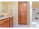 Well-lit bathroom with wood cabinets, storage, and shower-tub combo at 119 Wade Dr, Kings Mountain, NC 28086