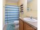 Bathroom with a blue striped shower curtain, shelves, and a wood vanity at 119 Wade Dr, Kings Mountain, NC 28086