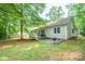 A home with a spacious backyard featuring a deck and lush greenery at 121 Jefferson Dr, Locust, NC 28097