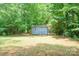 Backyard shed nestled in a verdant, wooded area with room for storage and projects at 121 Jefferson Dr, Locust, NC 28097