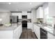 Contemporary kitchen with white cabinetry, stainless steel appliances, and an island with sleek granite countertops at 12109 Beaux Art Ln, Charlotte, NC 28214