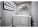 Functional laundry room equipped with a washer, dryer, and storage shelf at 12109 Beaux Art Ln, Charlotte, NC 28214