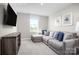 Stylish living room featuring a TV, comfortable sofa, and window at 12109 Beaux Art Ln, Charlotte, NC 28214