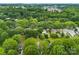 A lush, green aerial view of a neighborhood surrounded by mature trees and greenery at 122 Pratt St, Belmont, NC 28012