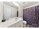 Bathroom featuring a white vanity, toilet, textured plum shower curtain, and a large mirror at 122 Pratt St, Belmont, NC 28012