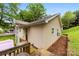 A charming home exterior featuring vinyl siding, wooden deck, manicured landscaping, and a wooded setting at 122 Pratt St, Belmont, NC 28012