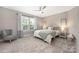 Bright bedroom featuring neutral walls, plush carpeting, and a stylish ceiling fan at 12220 Huntersville Concord Rd, Huntersville, NC 28078