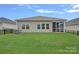 Exterior view of the home's backyard with a neatly kept lawn, black fencing, and a screened porch at 1344 Sweet Pea St, Monroe, NC 28110