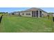 Spacious backyard showcasing the home's exterior, complete with manicured lawn, fencing, and screened in porch at 1344 Sweet Pea St, Monroe, NC 28110