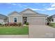 Charming one-story home featuring a well-manicured lawn, a two-car garage, and decorative landscaping at 1344 Sweet Pea St, Monroe, NC 28110