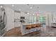 Open concept kitchen with central island, stainless appliances, and sliding glass door to outdoor living space at 1344 Sweet Pea St, Monroe, NC 28110
