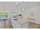 Open-concept kitchen with granite island, stainless sink, and view into a sunlit living room at 1344 Sweet Pea St, Monroe, NC 28110