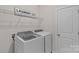 Efficient laundry room with modern, front-load washer and dryer, plus wire rack for extra storage at 1344 Sweet Pea St, Monroe, NC 28110