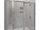 Modern bathroom shower featuring gray tiling, sliding glass door and convenient built in soap and shampoo niche at 1344 Sweet Pea St, Monroe, NC 28110