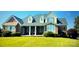 Inviting brick home featuring a well-manicured lawn, covered porch, and shuttered windows at 140 Hunters Hill Dr, Statesville, NC 28677