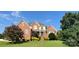 Charming brick home featuring a manicured lawn, mature trees, and inviting front entrance at 140 Hunters Hill Dr, Statesville, NC 28677
