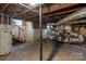 Unfinished basement with water heater, stairs, exposed ducts, and a small window at 1406 Upper Enochville Rd, Kannapolis, NC 28081