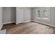 Bright bedroom showcasing warm vinyl flooring, double window and a paneled closet door at 1406 Upper Enochville Rd, Kannapolis, NC 28081