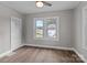 This bedroom features neutral walls, a ceiling fan, wood-look floors, and bright natural light from the windows at 1406 Upper Enochville Rd, Kannapolis, NC 28081