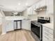 Well-lit kitchen featuring stainless steel appliances, white cabinets, and a view to the living area at 14123 Tranters Creek Ln, Charlotte, NC 28273