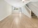 Open-concept living area with hardwood floors, staircase, and view to kitchen at 14123 Tranters Creek Ln, Charlotte, NC 28273