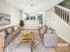 Staged living room featuring neutral tones, a plush rug, and a view of the open concept kitchen at 14123 Tranters Creek Ln, Charlotte, NC 28273