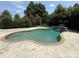 A backyard pool with clear water, a small waterfall, and surrounding landscaping at 14700 Old Vermillion Dr, Huntersville, NC 28078
