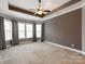 Spacious bedroom with tray ceilings, multiple windows, and neutral carpeting at 14700 Old Vermillion Dr, Huntersville, NC 28078