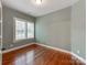 Cozy bedroom features hardwood floors, neutral paint, and a bright window that offers natural light and outdoor views at 14700 Old Vermillion Dr, Huntersville, NC 28078