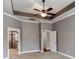 Large bedroom with tray ceilings, a ceiling fan, and two entryways at 14700 Old Vermillion Dr, Huntersville, NC 28078