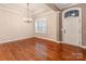 Formal dining room showcasing hardwood floors, an elegant chandelier, and bright window with views of the landscaped yard at 14700 Old Vermillion Dr, Huntersville, NC 28078