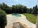 View of a backyard pool area featuring a lovely waterfall feature, concrete patio and manicured lawn at 14700 Old Vermillion Dr, Huntersville, NC 28078