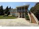 Rear exterior of tan home with multiple windows and staircase leading to screened in porch at 14700 Old Vermillion Dr, Huntersville, NC 28078