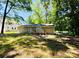 View of the backyard featuring a wood deck and mature tree coverage at 1583 Green Circle Dr, Gastonia, NC 28054