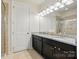 Bathroom has a double sink vanity, granite countertop, and a large mirror at 16213 Kelby Cv, Charlotte, NC 28278