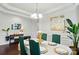 Elegant dining area featuring an oval table with setting, a chandelier, and accent wall art at 16213 Kelby Cv, Charlotte, NC 28278