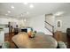 Open dining room showcases a hardwood floor, wood table and view to the kitchen and staircase at 16213 Kelby Cv, Charlotte, NC 28278