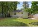 Large backyard featuring lush green grass, wooden fence, string lights, and back access at 1713 Shamrock Dr, Charlotte, NC 28205