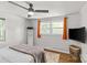 Bedroom featuring hardwood floors, two windows with orange curtains, and a ceiling fan at 1713 Shamrock Dr, Charlotte, NC 28205