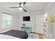 Well-lit bedroom with ceiling fan, hardwood floors, and a colorful accent cabinet at 1713 Shamrock Dr, Charlotte, NC 28205