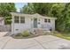 Charming white brick home with landscaped front yard, concrete driveway, and welcoming green front door at 1713 Shamrock Dr, Charlotte, NC 28205