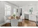 Cozy kitchen featuring white cabinets, stainless steel appliances, and a breakfast nook with a round table at 1713 Shamrock Dr, Charlotte, NC 28205